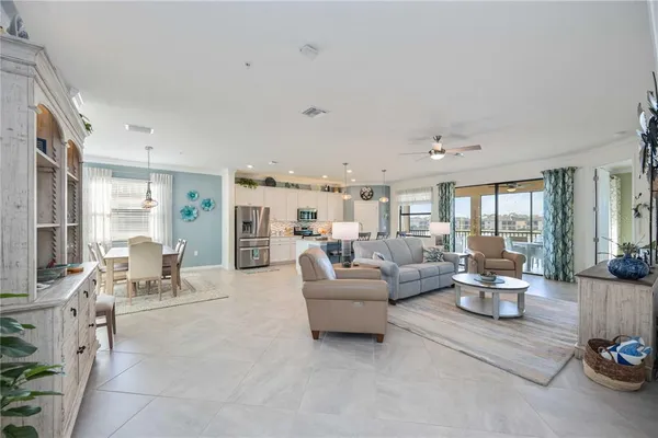 a living room with furniture kitchen view and a refrigerator
