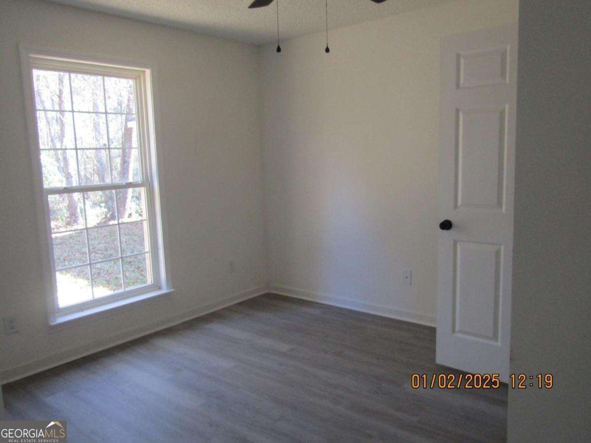 7358 Stilson-Leefield Road Brooklet, GA 30415 - Photo 15 of 24 an empty room with wooden floor and windows