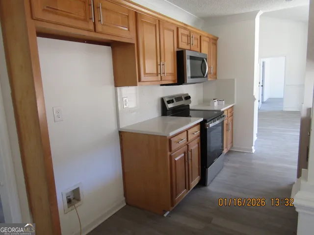 a kitchen with stainless steel appliances granite countertop a stove top oven a sink a refrigerator and dishwasher