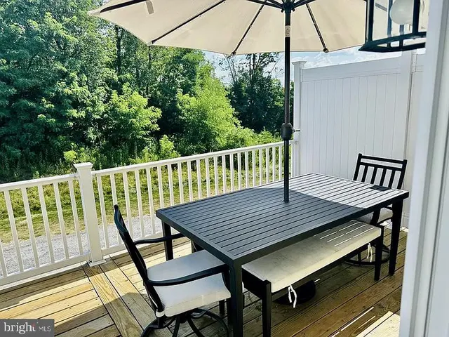 a roof deck with a table and chairs under an umbrella