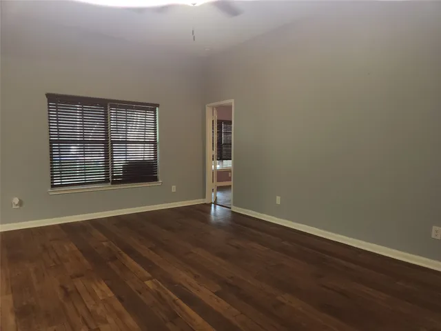 a view of a house with a yard plants and large tree