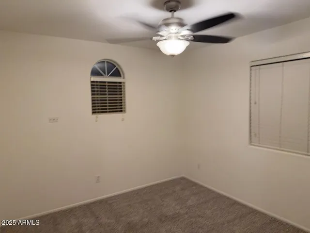 an empty room with a chandelier fan