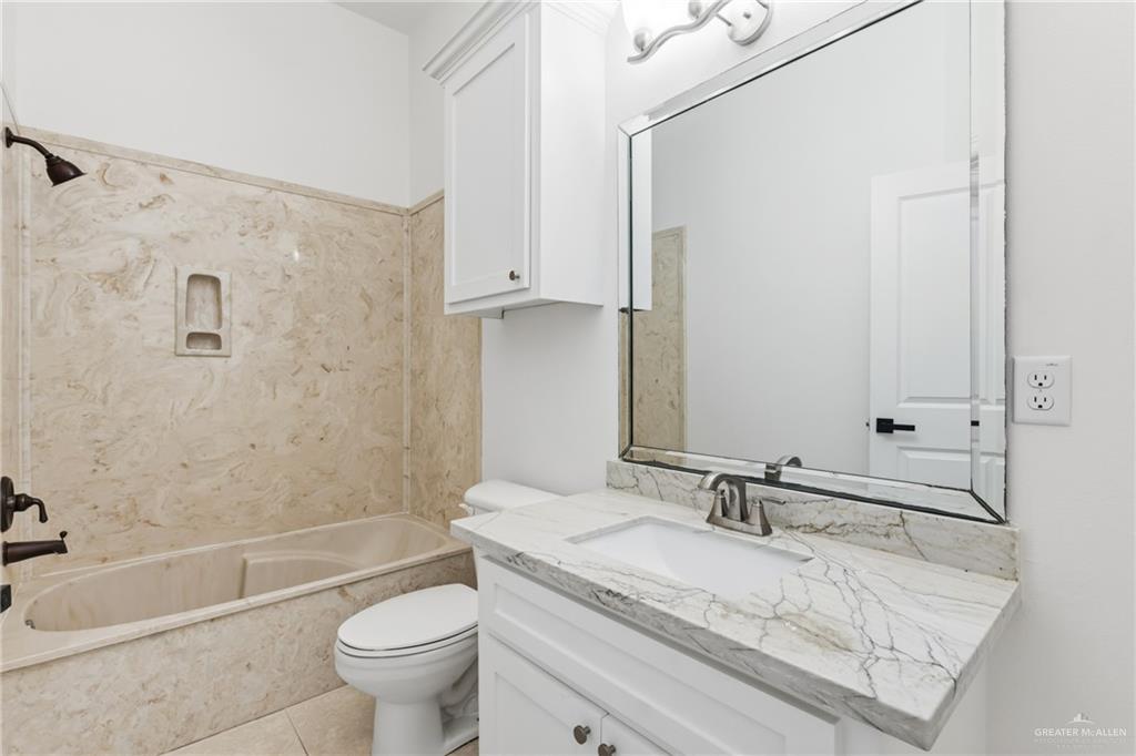 513 Mi Vida Street Weslaco, TX 78596 - Photo 18 of 22 a bathroom with a granite countertop sink a toilet and bathtub