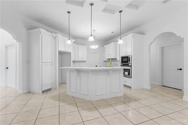 a large kitchen with white cabinets and stainless steel appliances