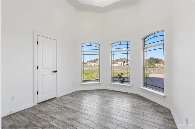 an empty room with windows and cabinet