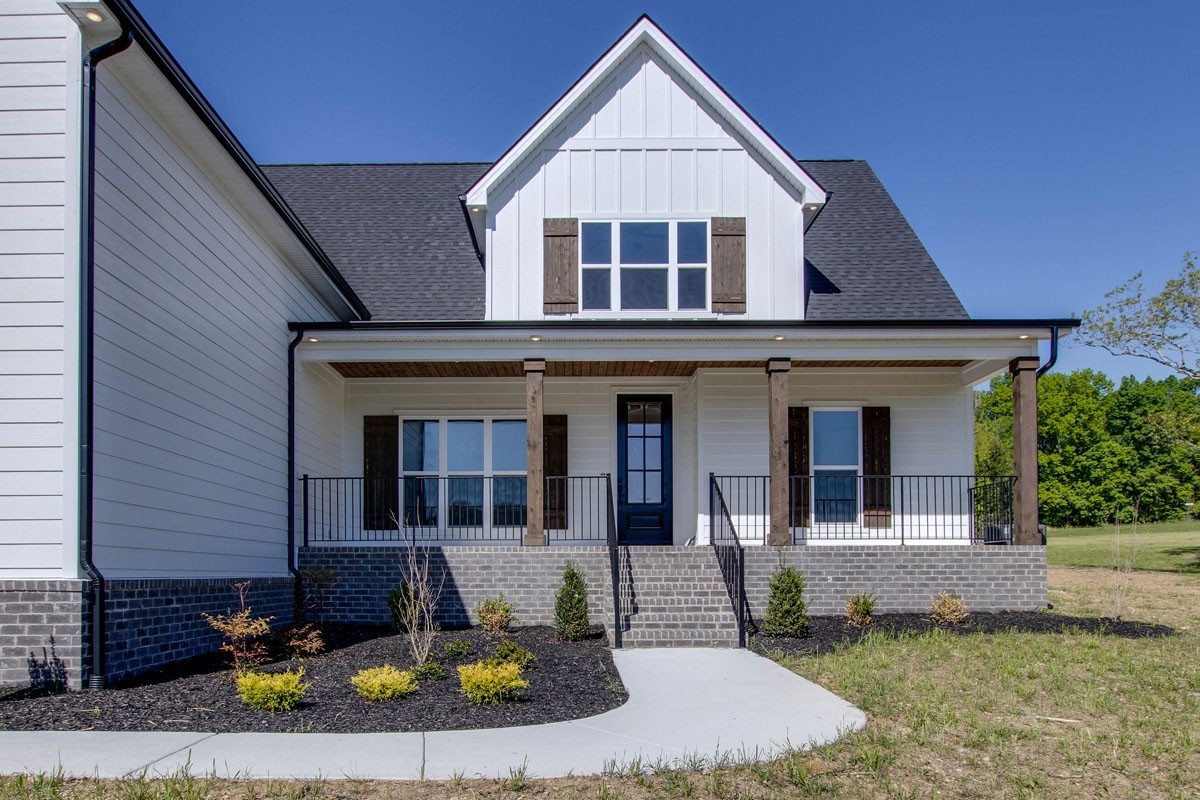 7311 North Milton Road Milton, TN 37118 - Photo 5 of 54 a view of a white house with large windows and a yard