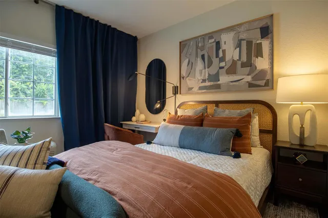 a bedroom with a bed and a large mirror