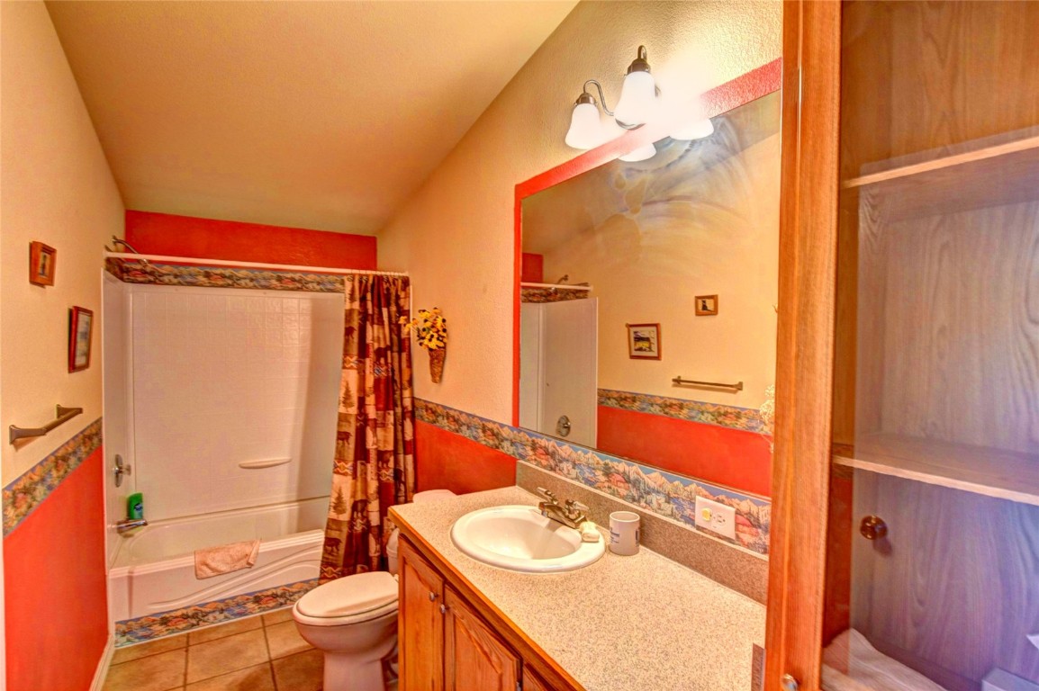 735 Apache Trail Como, CO 80456 - Photo 19 of 37 a bathroom with a granite countertop sink toilet mirror vanity and shower