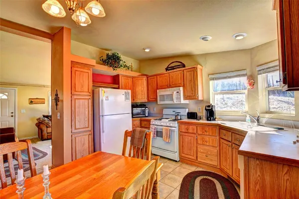 a kitchen with stainless steel appliances a dining table chairs stove refrigerator and sink