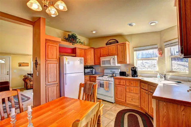 a kitchen with stainless steel appliances a dining table chairs stove refrigerator and sink