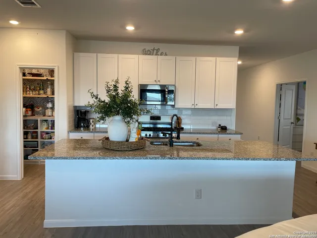a kitchen with stainless steel appliances granite countertop a refrigerator and a stove