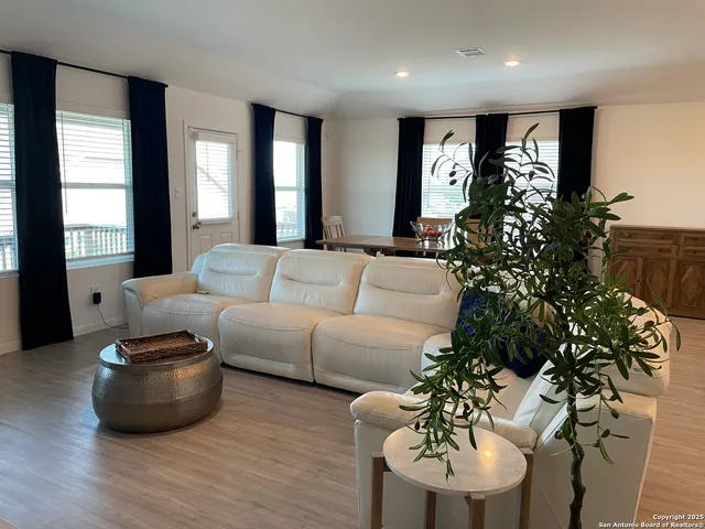 a living room with furniture and large windows