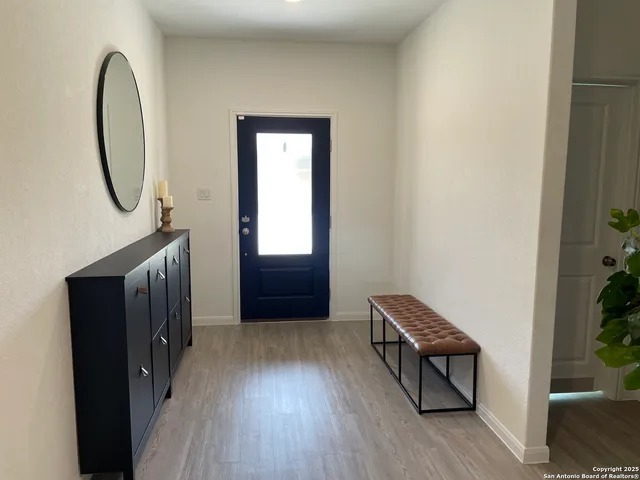 a view of a hallway with wooden floor and entryway