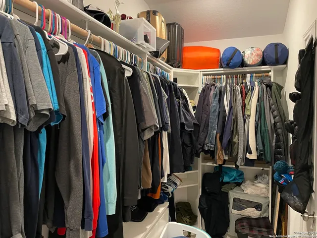 a view of walk in closet with clothes and shoes