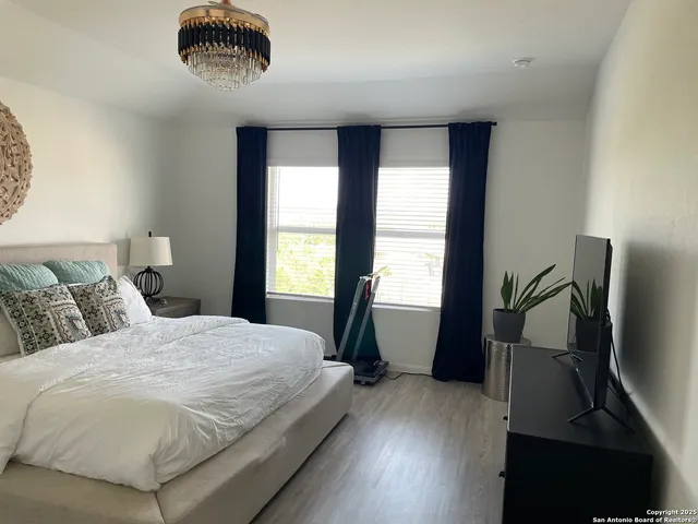 a bedroom with a bed and a lamp on dresser