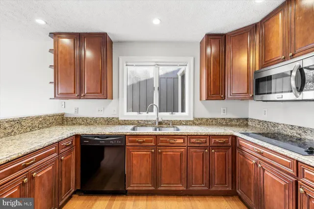a kitchen with stainless steel appliances granite countertop a sink stove and cabinets