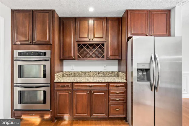 a kitchen with granite countertop a refrigerator stove and microwave