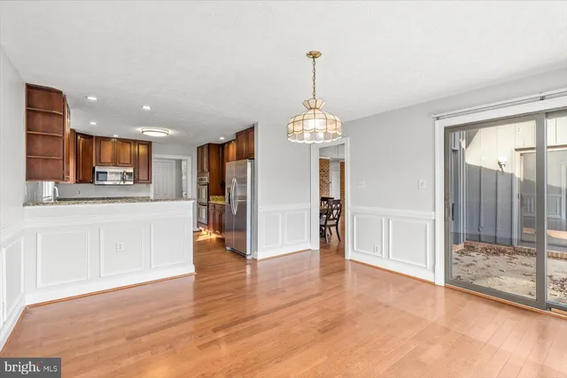 a view of a kitchen with refrigerator and wooden floor