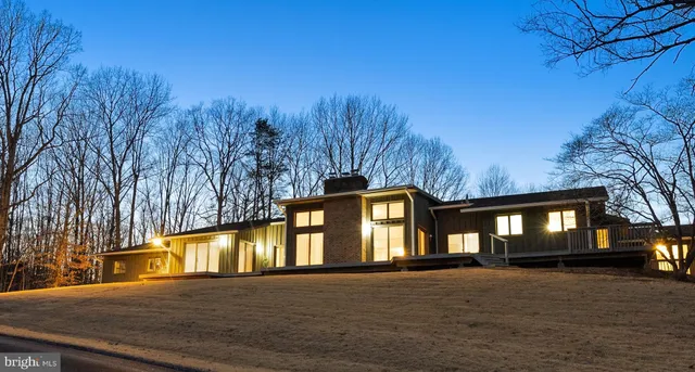 a view of an house with backyard and trees
