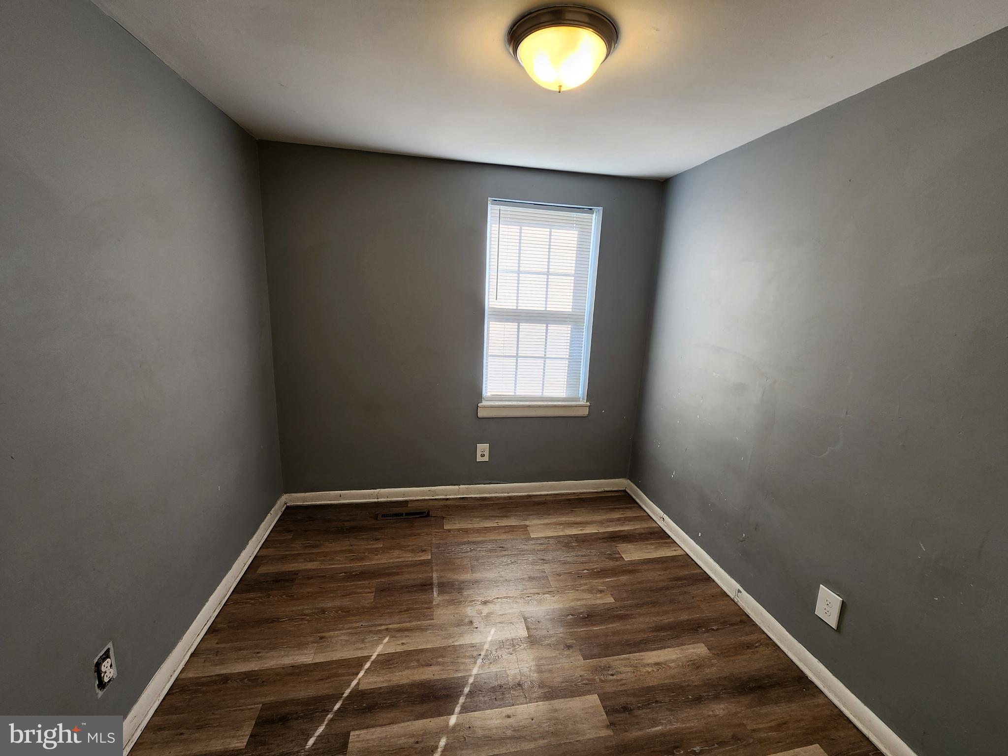 819 Aisquith Street Baltimore, MD 21202 - Photo 14 of 24 an empty room with wooden floor and windows
