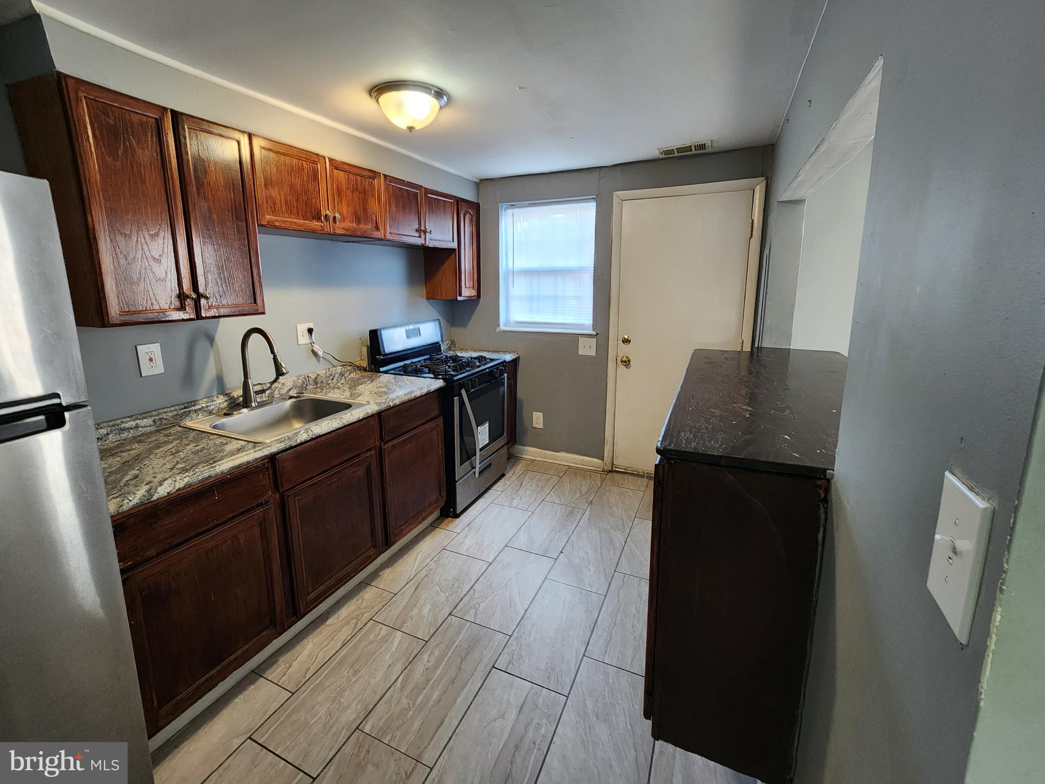 819 Aisquith Street Baltimore, MD 21202 - Photo 6 of 24 a kitchen with a sink stove and refrigerator