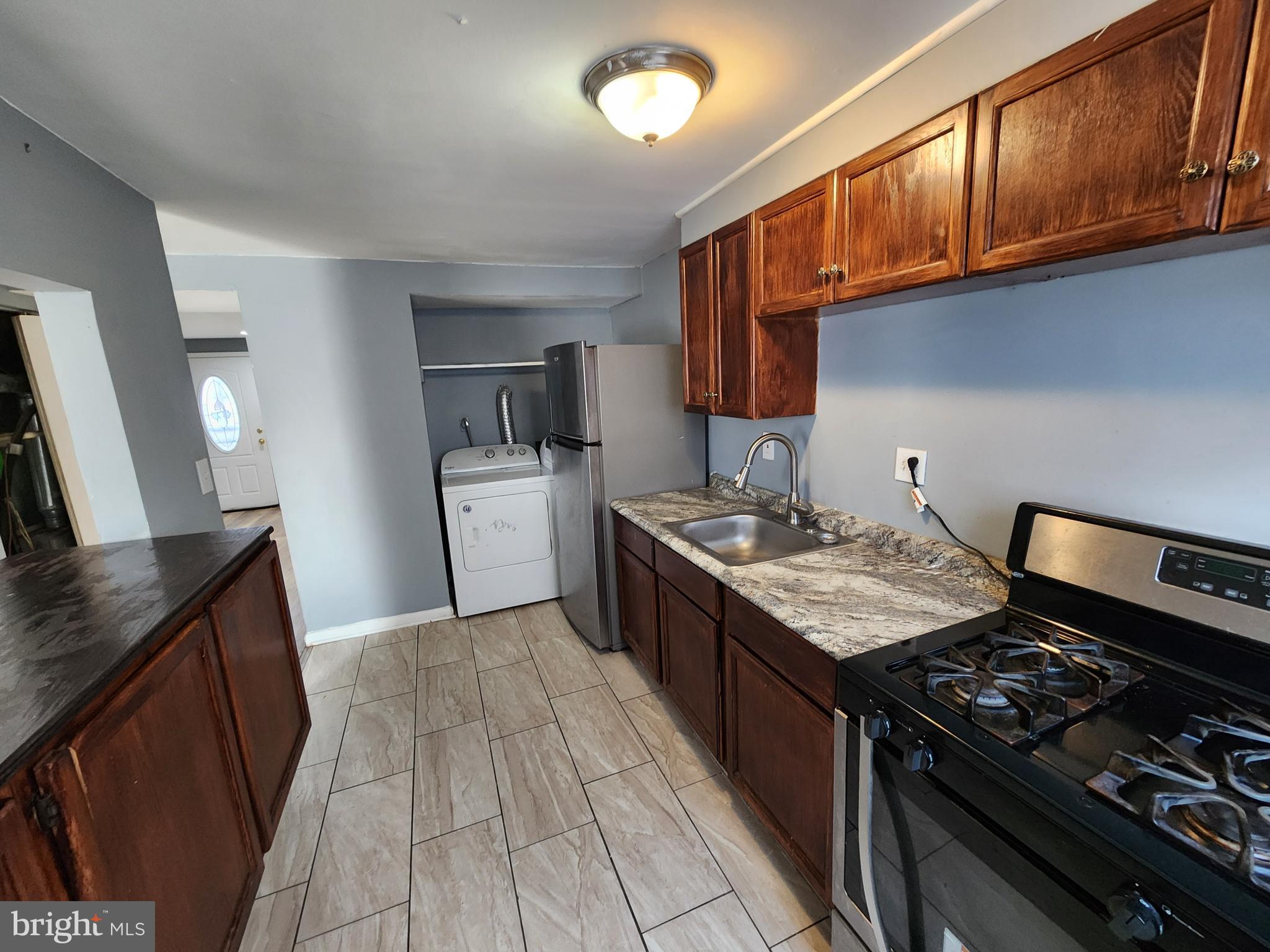 819 Aisquith Street Baltimore, MD 21202 - Photo 7 of 24 a kitchen with stainless steel appliances granite countertop a stove and a sink