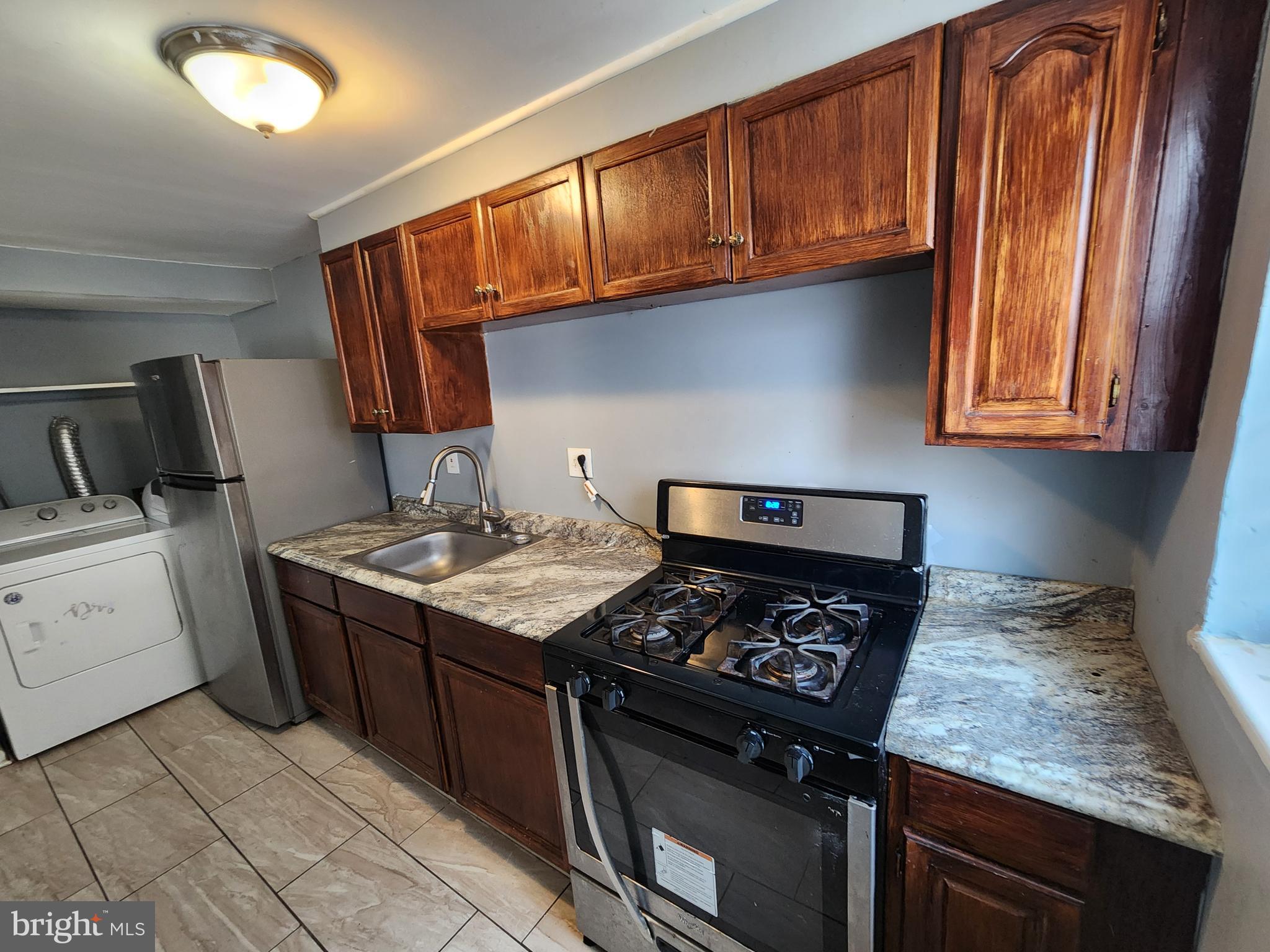 819 Aisquith Street Baltimore, MD 21202 - Photo 8 of 24 a kitchen with granite countertop a stove sink and cabinets
