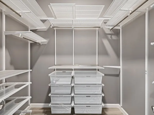 a view of walk in closet with empty racks