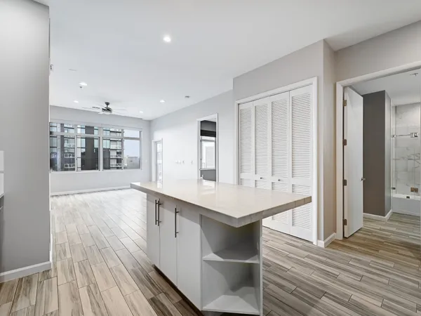 a view of kitchen with kitchen island wooden floor and window