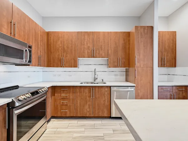 a kitchen with stainless steel appliances wooden cabinets and a stove top oven