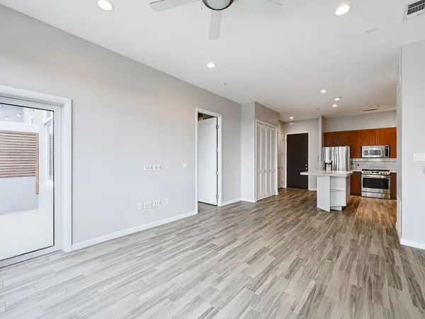 a view of a kitchen with a refrigerator a ceiling fan and wooden floor