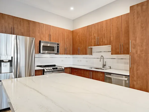 a kitchen with granite countertop a sink stainless steel appliances and cabinets