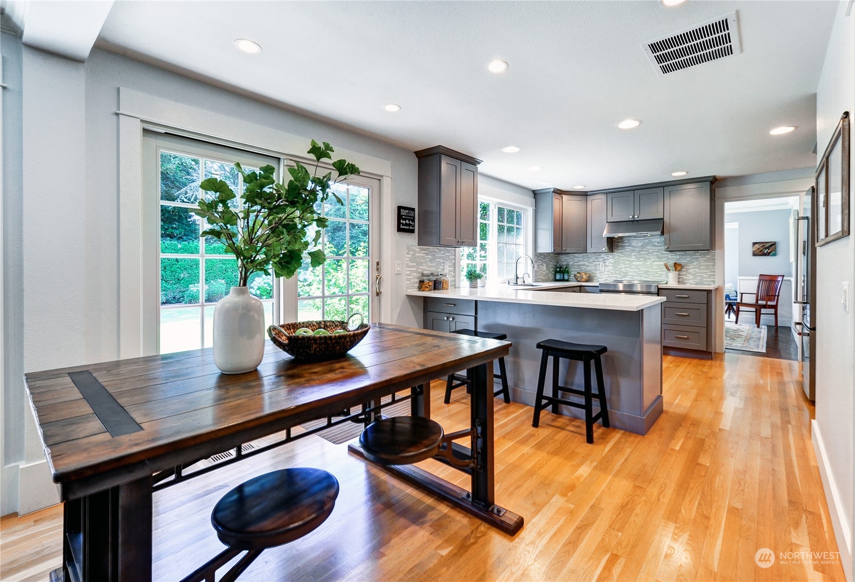 25 Cascade Key Bellevue, WA 98006 - Photo 10 of 33 a kitchen with stainless steel appliances granite countertop a stove a refrigerator a sink a dining table and chairs with wooden floor