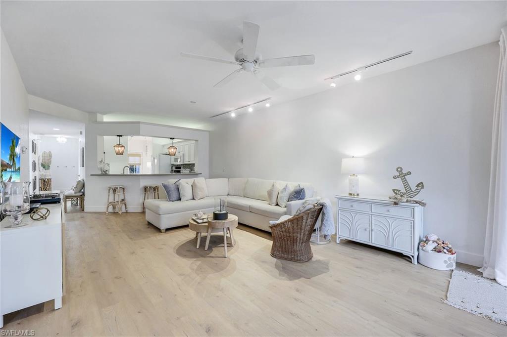 7108 Barrington Circle Naples, FL 34108 - Photo 6 of 25 a living room with furniture and a chandelier