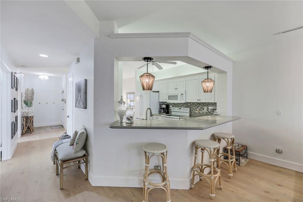 7108 Barrington Circle Naples, FL 34108 - Photo 10 of 25 a kitchen with stainless steel appliances kitchen island granite countertop a table and chairs in it