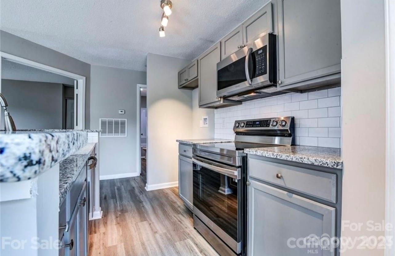 8179 Cedar Glen Drive Charlotte, NC 28212 - Photo 2 of 9 a kitchen with stainless steel appliances granite countertop a refrigerator a stove top oven a sink and dishwasher