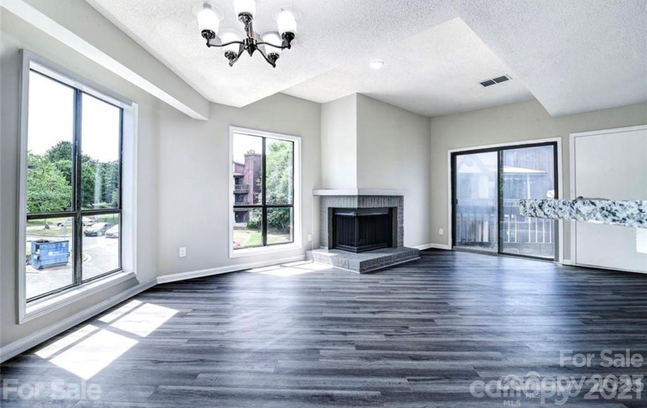 8179 Cedar Glen Drive Charlotte, NC 28212 - Photo 3 of 9 a view of an empty room with window wooden floor and a fireplace