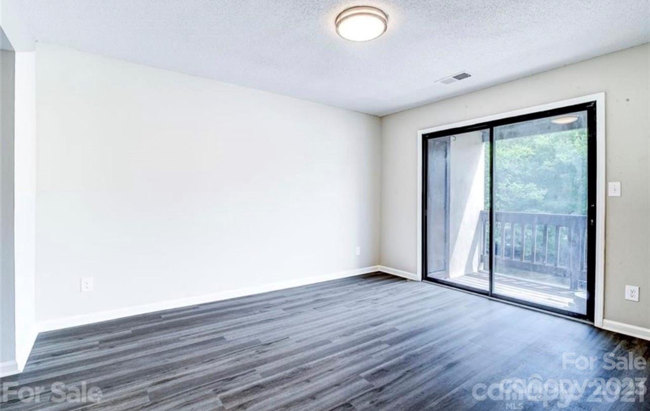 8179 Cedar Glen Drive Charlotte, NC 28212 - Photo 6 of 9 a view of an empty room with wooden floor and a window