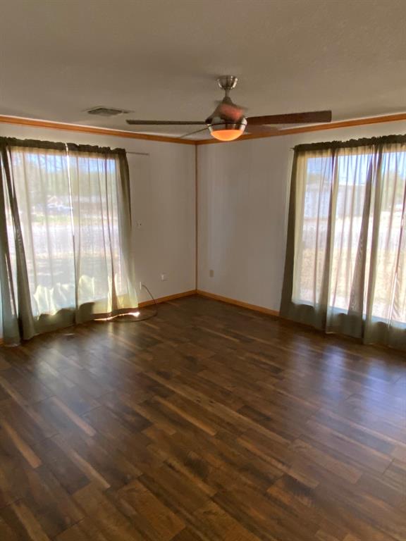 104 County Road 1296 Morgan, TX 76671 - Photo 15 of 27 an empty room with wooden floor and windows with curtains