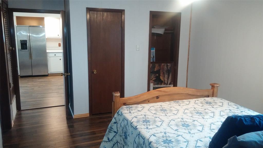 104 County Road 1296 Morgan, TX 76671 - Photo 18 of 27 a bedroom with a bed and wooden floor