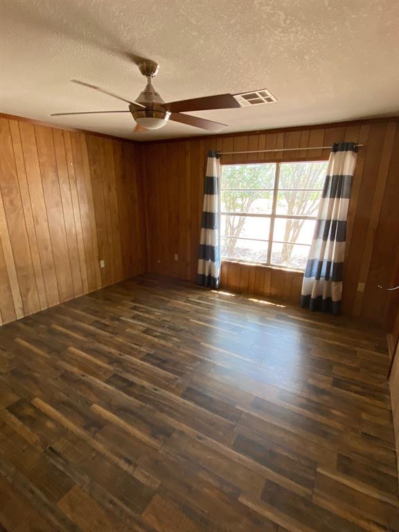 104 County Road 1296 Morgan, TX 76671 - Photo 6 of 27 an empty room with wooden floor and windows