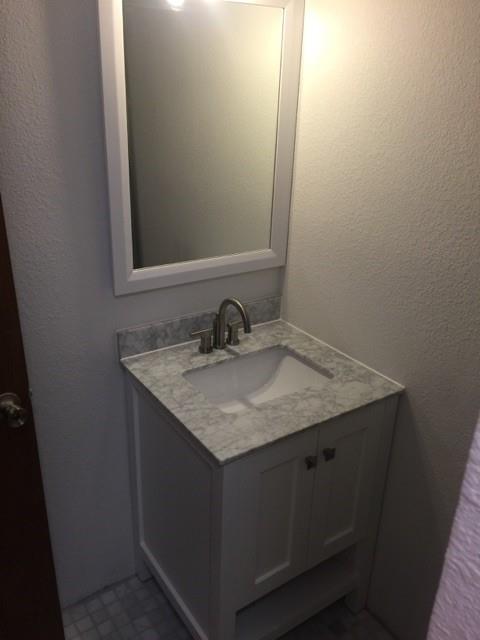 104 County Road 1296 Morgan, TX 76671 - Photo 9 of 27 a bathroom with a granite countertop sink and a mirror