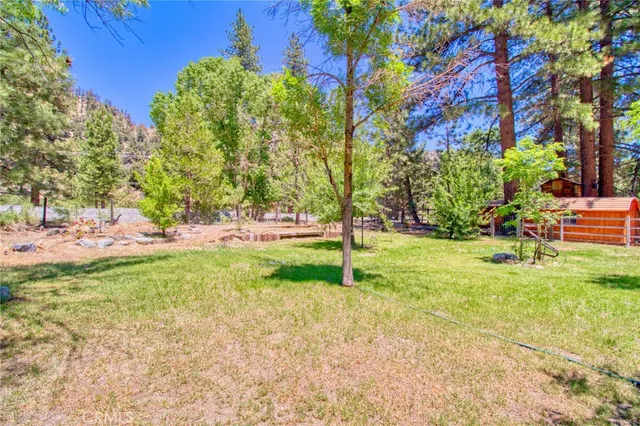 an aerial view of residential house with outdoor space and trees all around