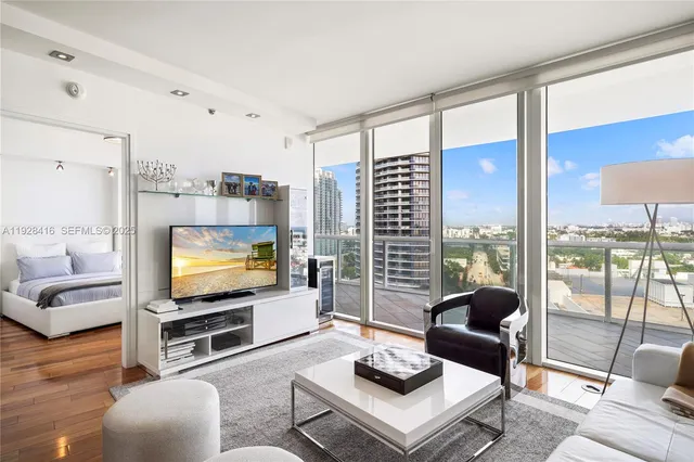 a living room with furniture a flat screen tv and a large window