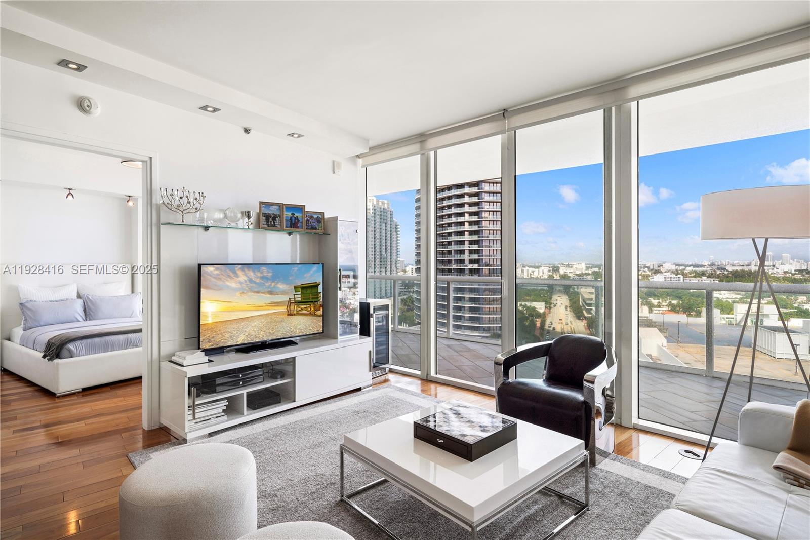 450 Alton Road, Unit 1610 Miami Beach, FL 33139 - Photo 11 of 32 a living room with furniture a flat screen tv and a large window