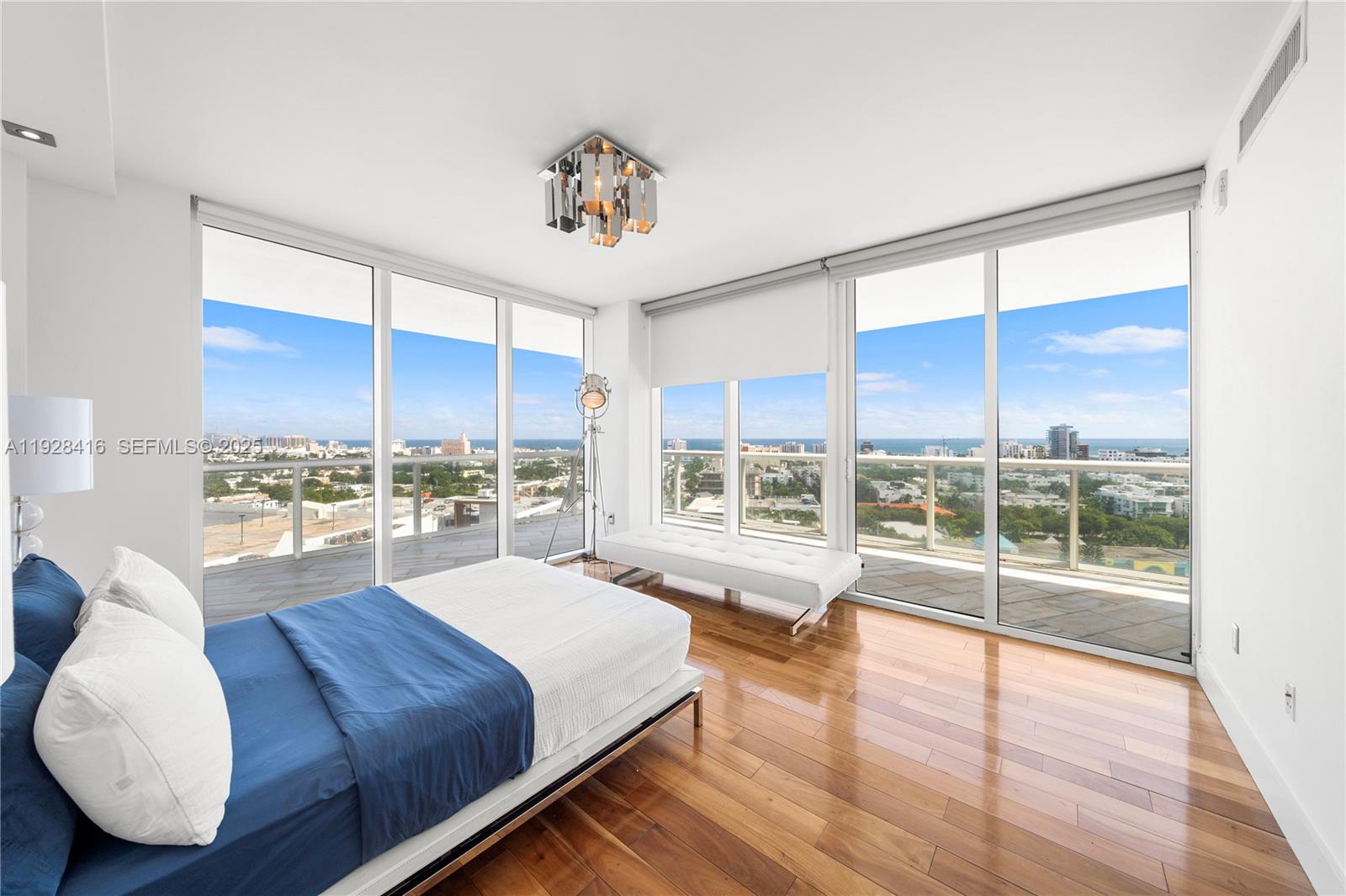 450 Alton Road, Unit 1610 Miami Beach, FL 33139 - Photo 12 of 32 a spacious bedroom with a large window and a wooden floor