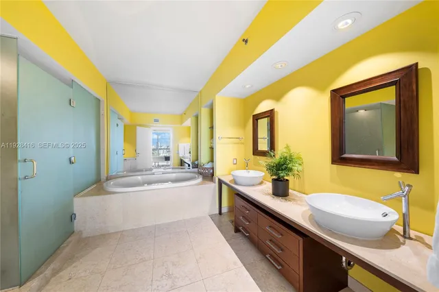 a spacious bathroom with a double vanity sink a mirror and a bathtub