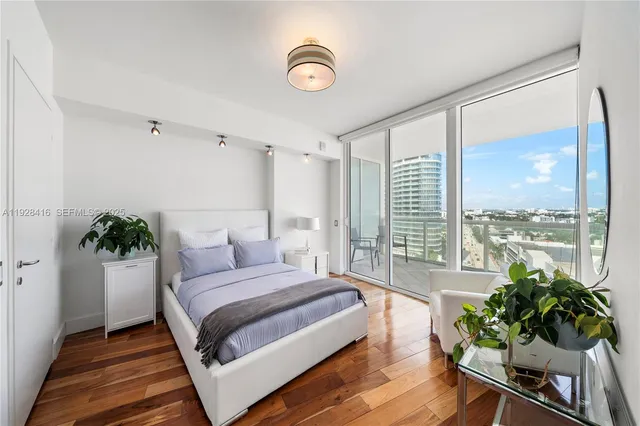 a spacious bedroom with a large bed and a potted plant