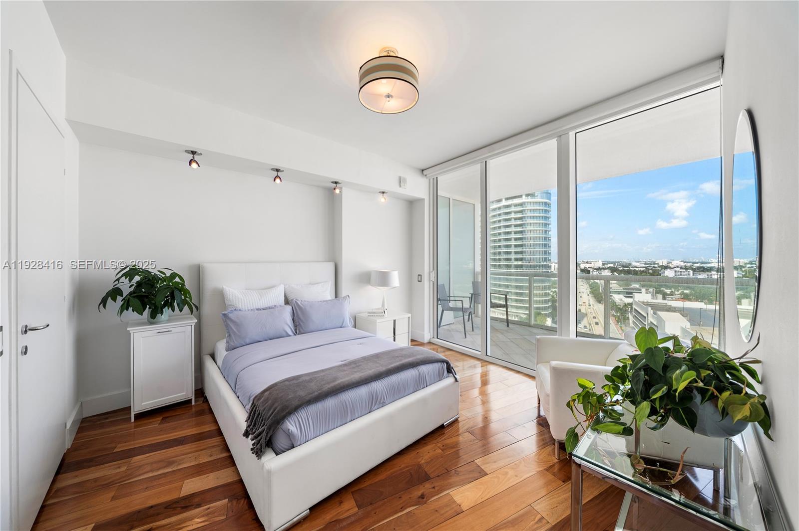450 Alton Road, Unit 1610 Miami Beach, FL 33139 - Photo 18 of 32 a spacious bedroom with a large bed and a potted plant