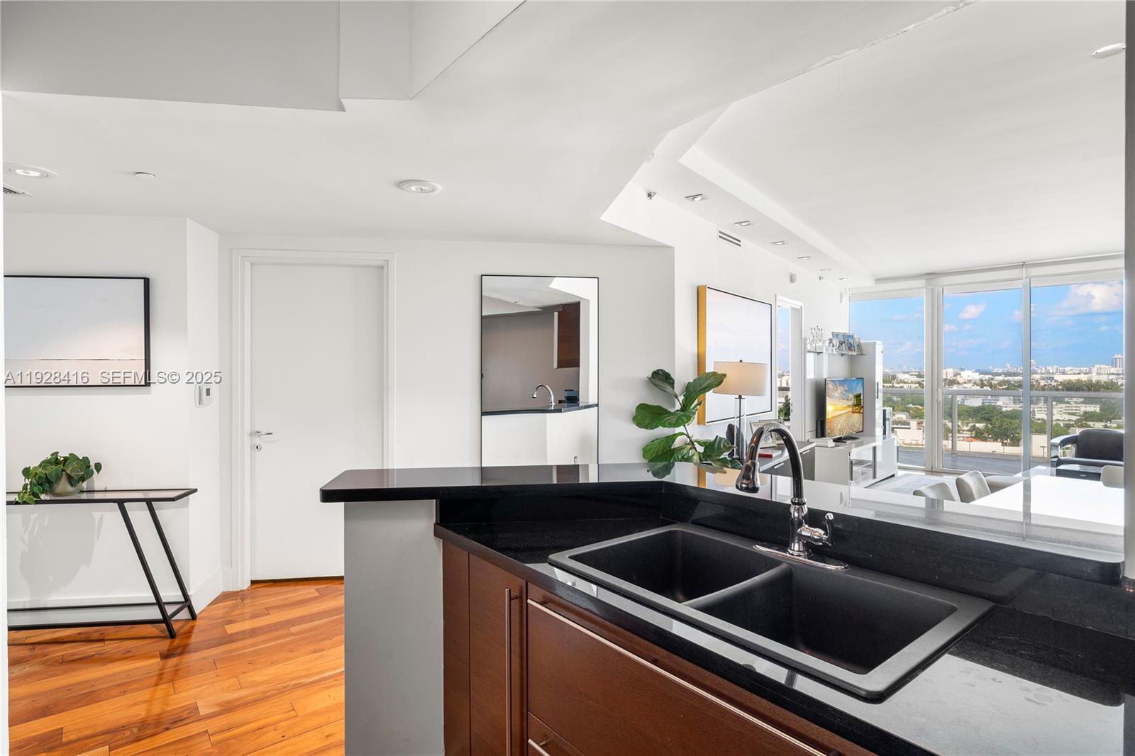 450 Alton Road, Unit 1610 Miami Beach, FL 33139 - Photo 3 of 32 a kitchen with a sink and a refrigerator